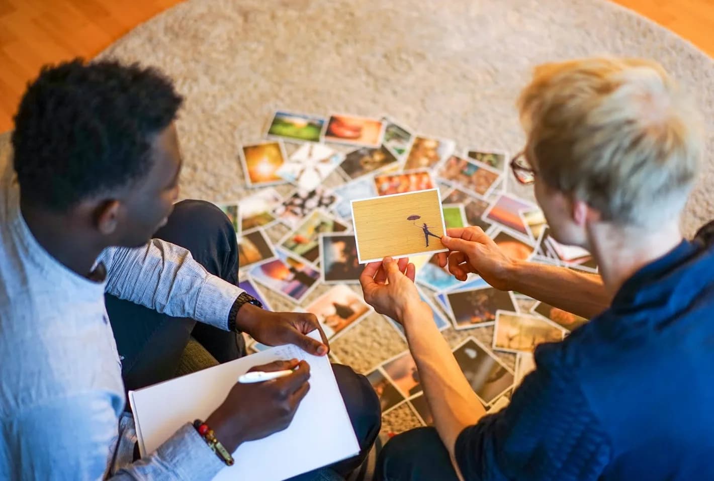 A coach and client reflecting together with cards in person
